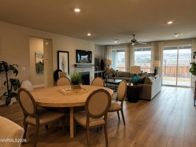 a living room with furniture a large window and wooden floor