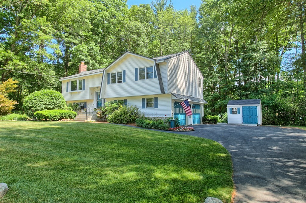 130 Ferncroft Road Tewksbury, MA 01876 - Photo 2 of 29 a front view of a house with a yard and trees