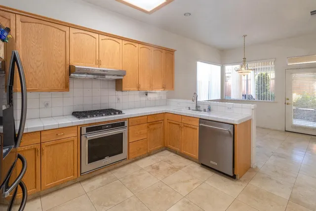 a kitchen with granite countertop a sink stove and cabinets
