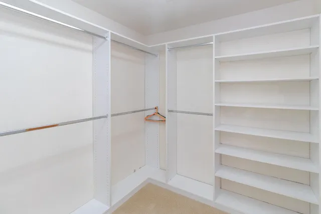 a view of walk in closet with empty racks