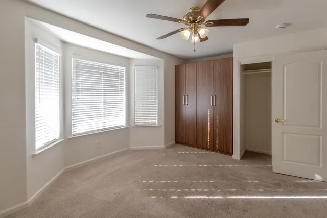 a view of a livingroom with a ceiling fan and window