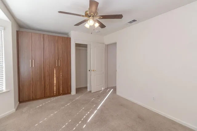 an empty room with a ceiling fan and a window