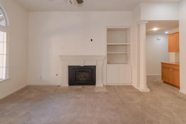 a view of an empty room with a fireplace and a window
