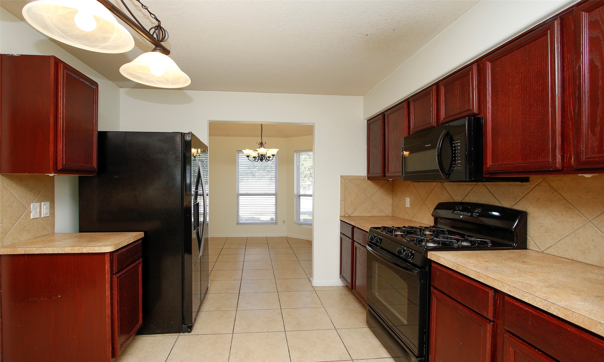 9812 Expedition Trail Conroe, TX 77385 - Photo 14 of 37 a kitchen with a refrigerator stove and sink
