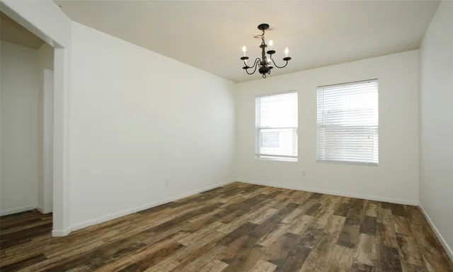 a view of a room with a chandelier fan and windows