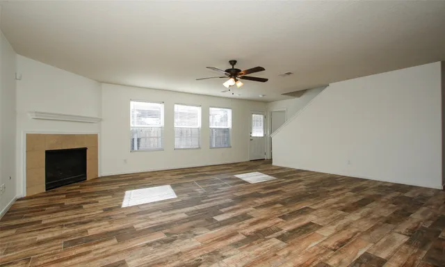 a view of an empty room with window and a fireplace