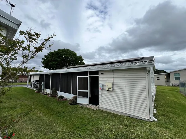 a view of a house with a yard and sitting area