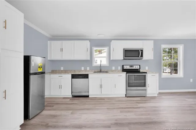 a kitchen with granite countertop a refrigerator stove and microwave
