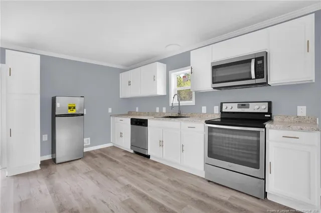 a kitchen with granite countertop a refrigerator stove and sink