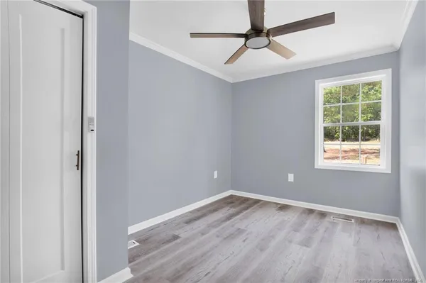 an empty room with a window and a fan