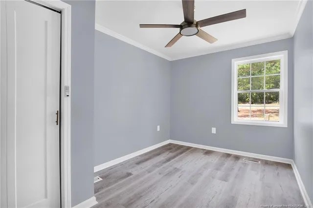 an empty room with a window and a fan