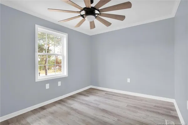 an empty room with a window and a fan