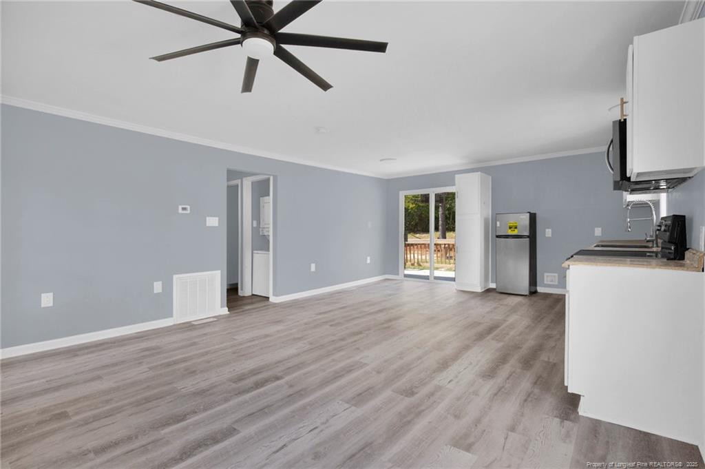 266 Brower Road Cameron, NC 28326 - Photo 9 of 26 a view of a livingroom with a flat screen tv wooden floor and a ceiling fan