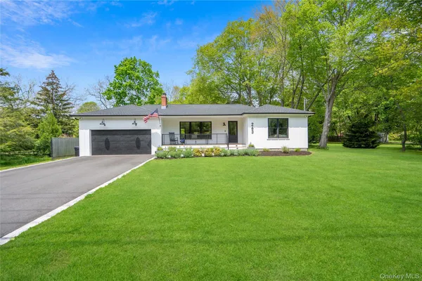 a front view of a house with a yard and green space