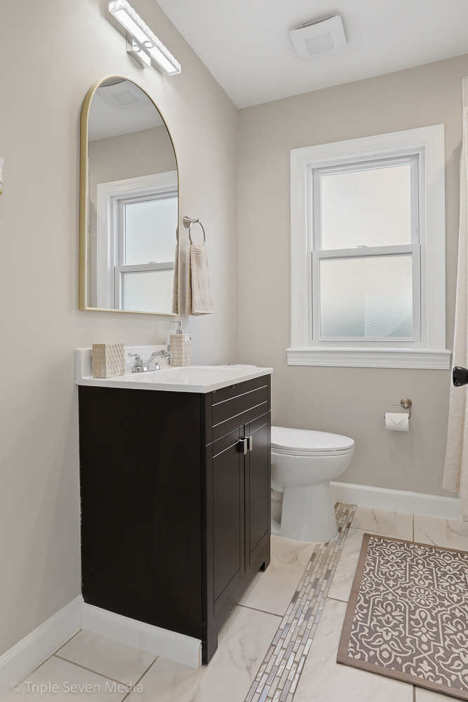 9149 South Aberdeen Street Chicago, IL 60620 - Photo 18 of 46 a bathroom with a toilet a sink a vanity and mirror