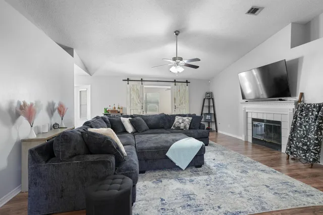 a living room with furniture a fireplace and a flat screen tv