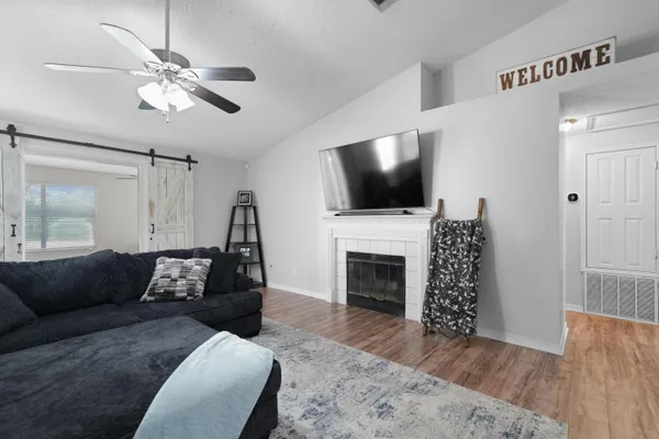 a living room with furniture a fireplace and a flat screen tv