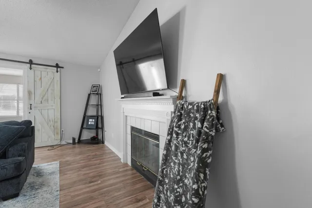 a living room with furniture a fireplace and a flat screen tv