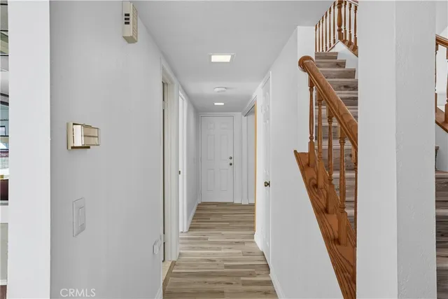 a view of a hallway with wooden floor and stairs