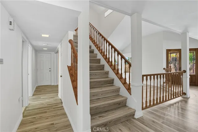 a view of a hallway with wooden floor and stairs