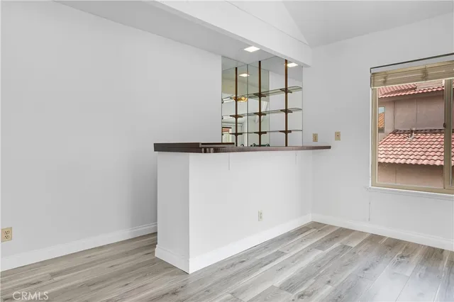 an empty room with wooden floor and window