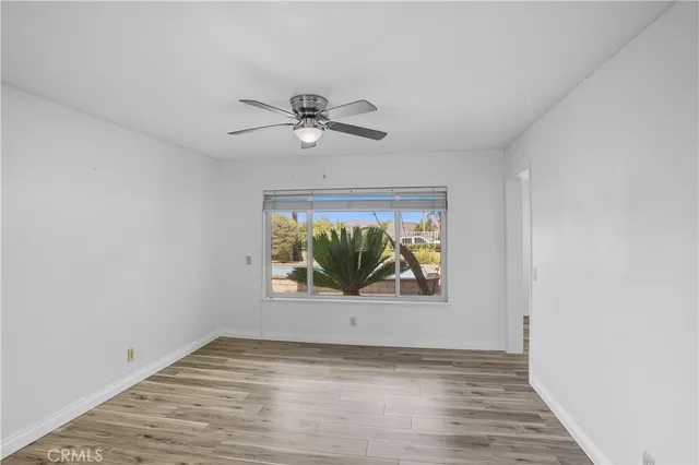 a view of room with window ceiling fan and hardwood floor