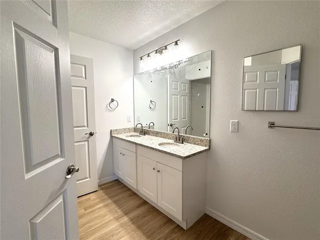 a bathroom with a granite countertop sink mirror and shower