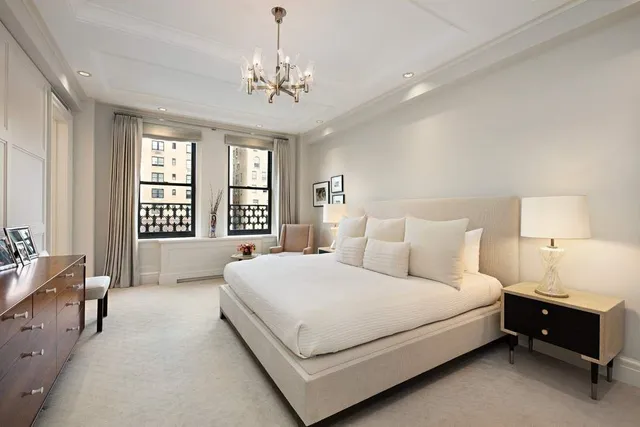 a bedroom with a large bed and a chandelier