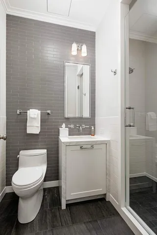 a bathroom with a toilet a sink and mirror