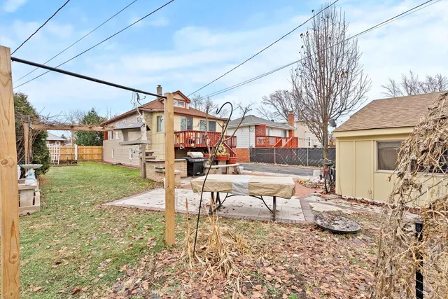 a view of a house with backyard and a tree