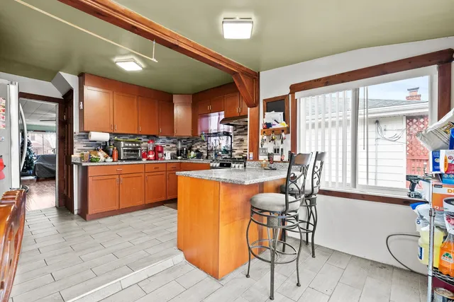 a kitchen with stainless steel appliances kitchen island granite countertop a table and chairs in it