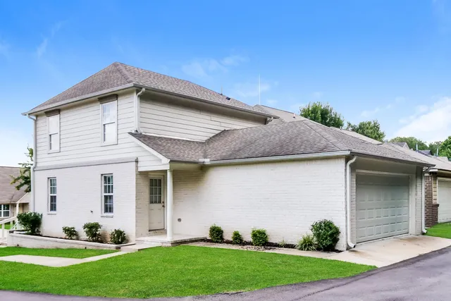 a front view of a house with a yard and potted plants