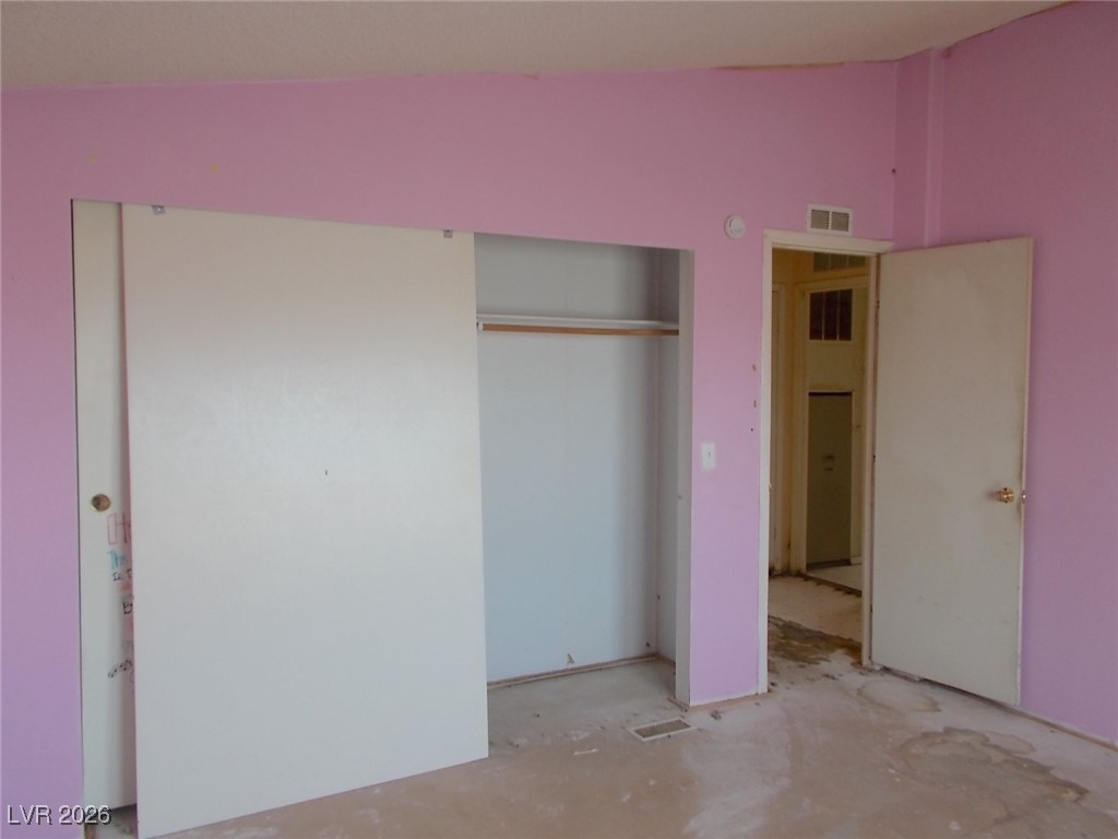 171 Paradise Road Alamo, NV 89001 - Photo 13 of 21 Unfurnished bedroom featuring unfinished concrete floors, a closet, and vaulted ceiling
