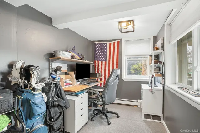 a view of a workspace with furniture and a window