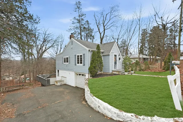 a front view of a house with a garden and trees