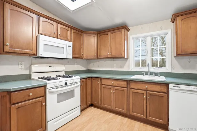 a kitchen with granite countertop cabinets stainless steel appliances a sink and a window