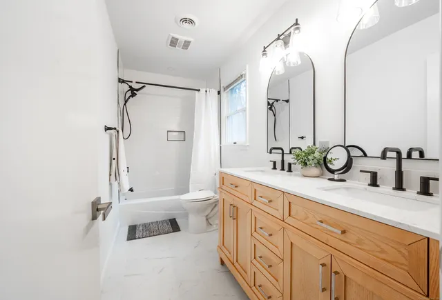a bathroom with a double vanity sink mirror double and shower