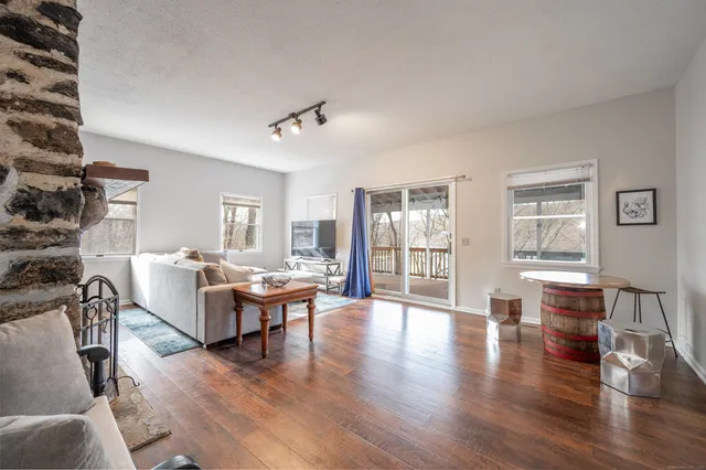 a living room with couches chairs and wooden floor