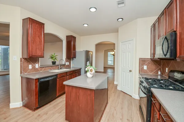 a kitchen with stainless steel appliances granite countertop a sink stove and refrigerator