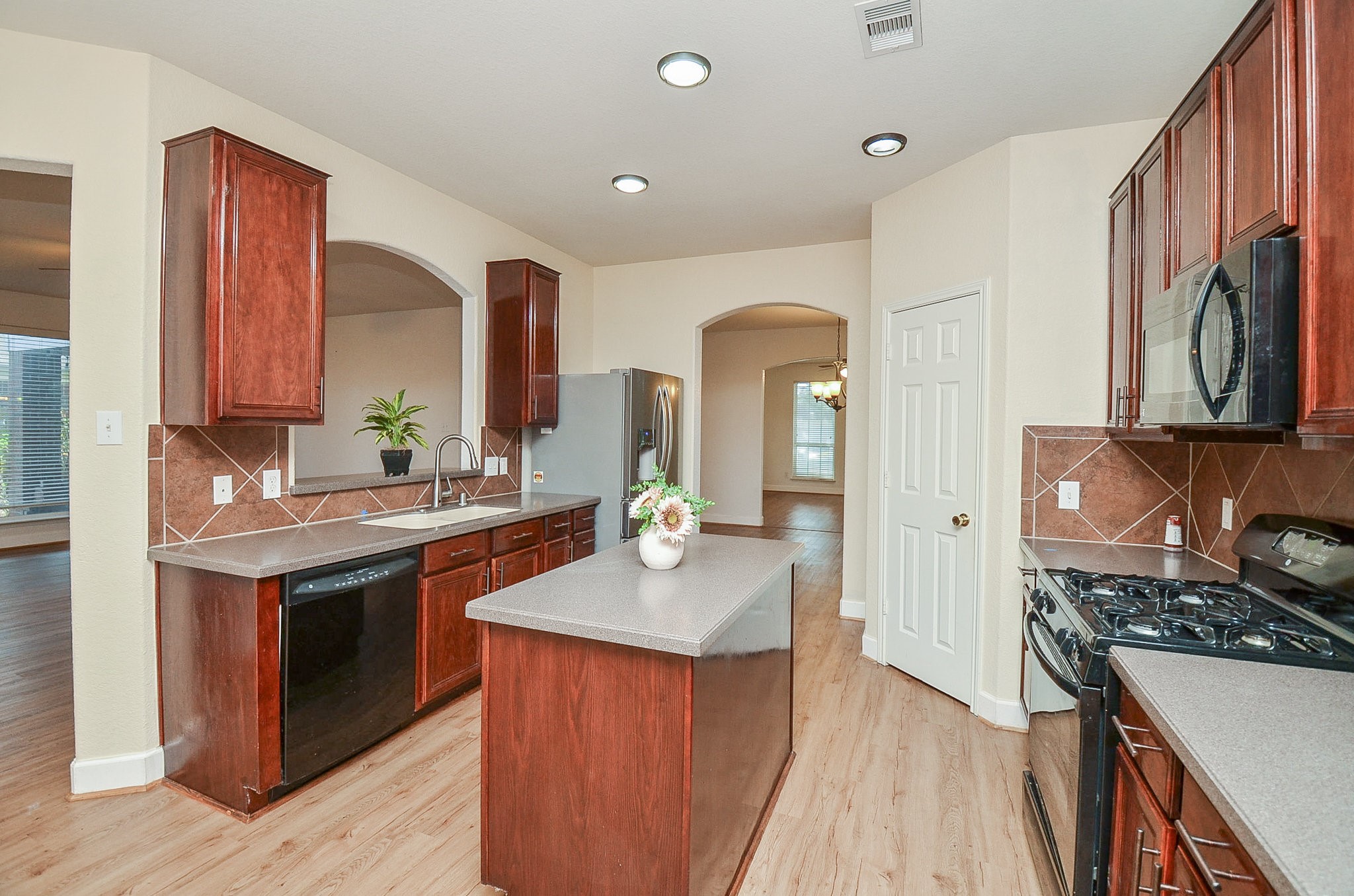 3003 Sage Grouse Court Rosenberg, TX 77471 - Photo 14 of 34 a kitchen with stainless steel appliances granite countertop a sink stove and refrigerator
