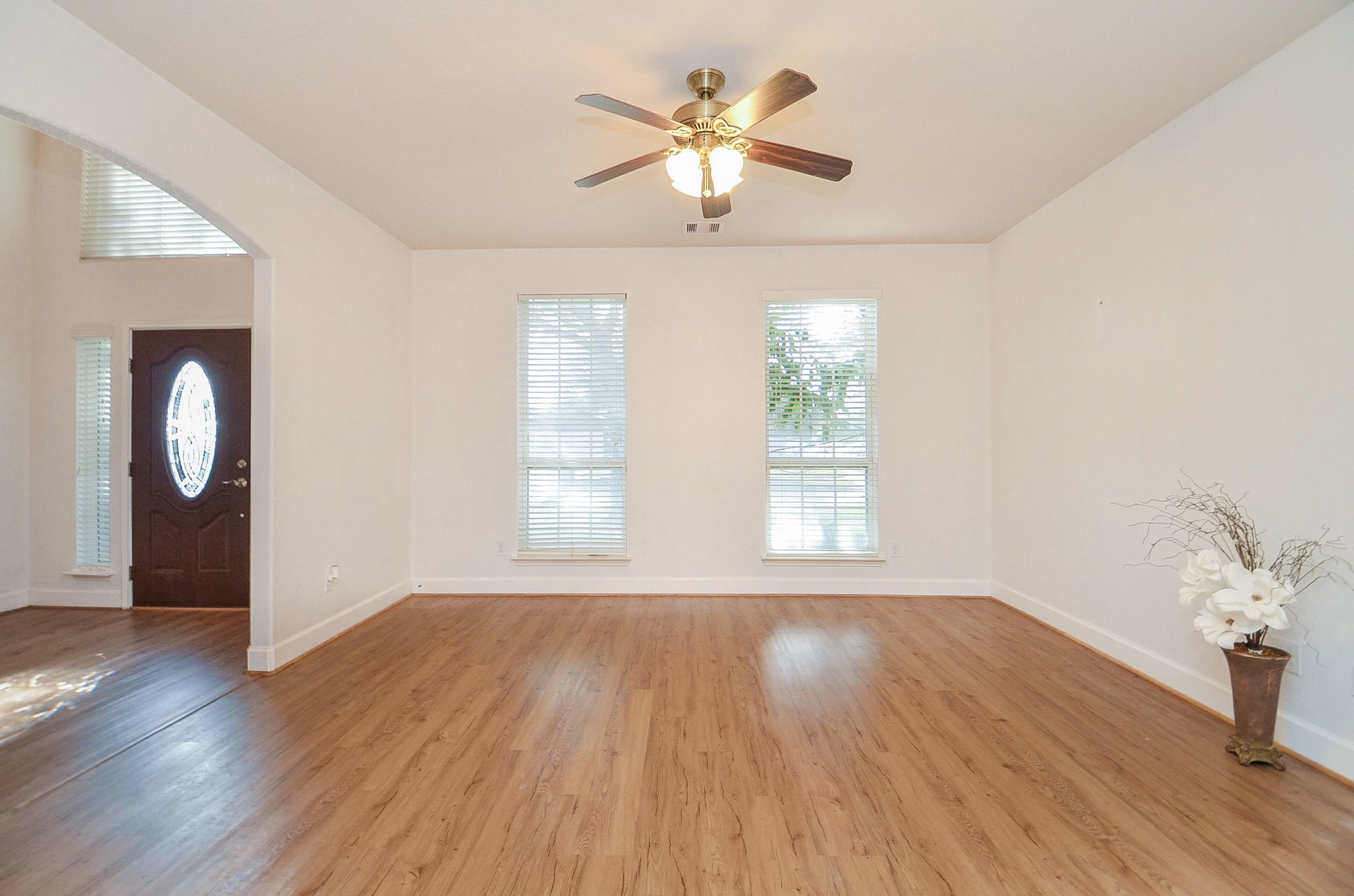 3003 Sage Grouse Court Rosenberg, TX 77471 - Photo 2 of 34 an empty room with wooden floor chandelier fan and windows