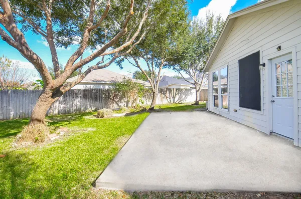 a view of a house with backyard and tree