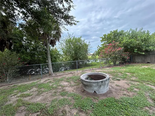a view of a chair and table in backyard of the house