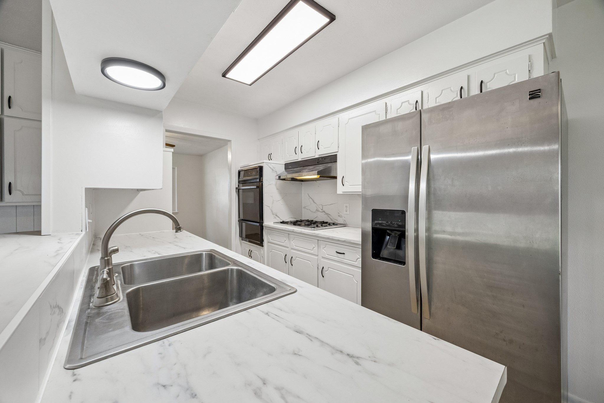 4903 Mistletoe Road Pasadena, TX 77505 - Photo 6 of 10 a kitchen with a refrigerator sink and cabinets