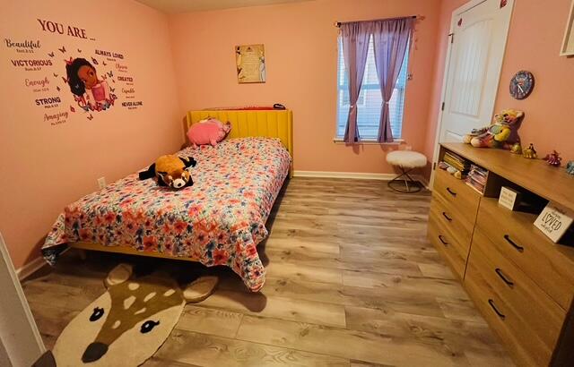 473 Earl Godwin Road Freeport, FL 32439 - Photo 9 of 25 a bedroom with a bed and wooden floor