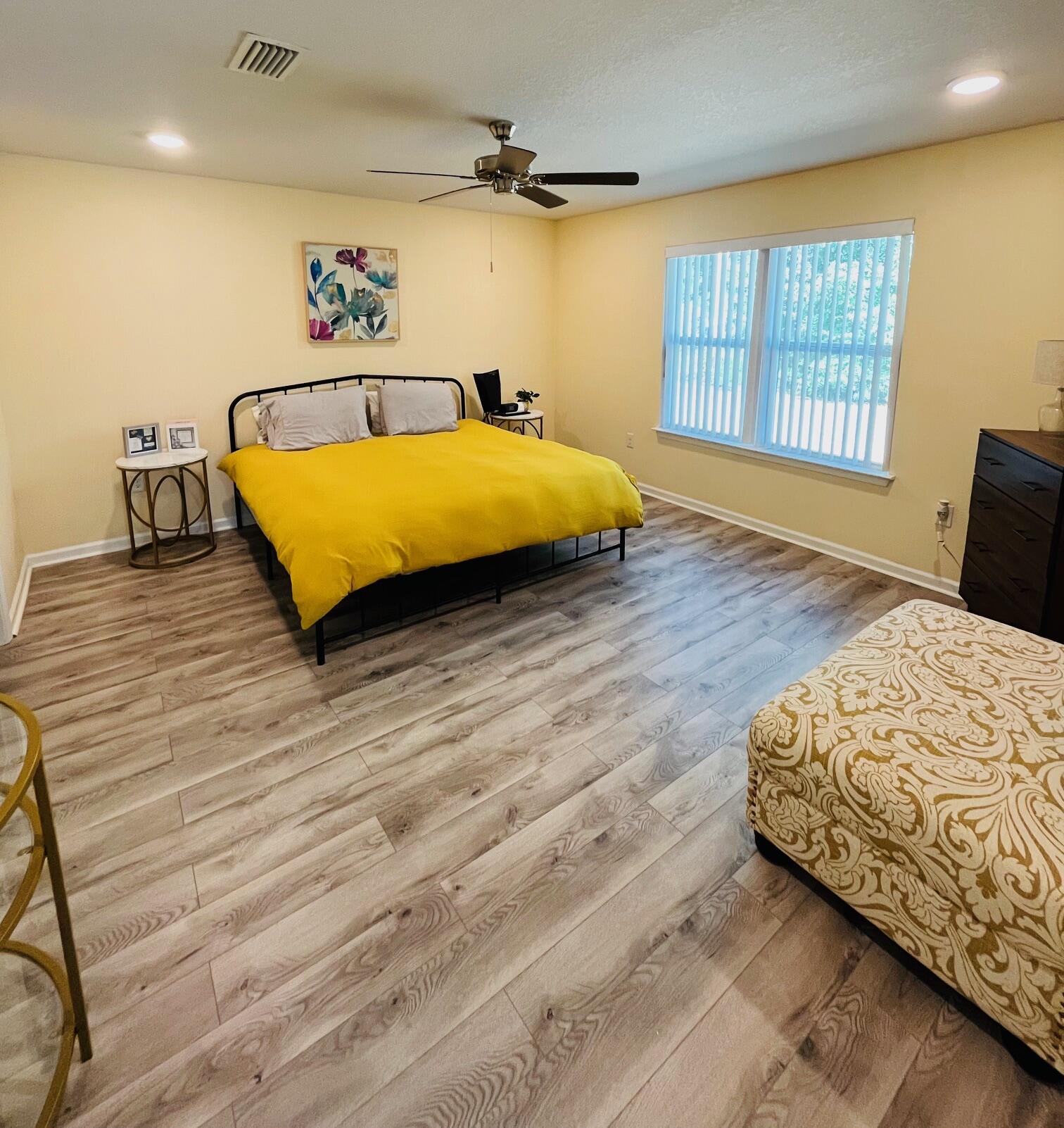 473 Earl Godwin Road Freeport, FL 32439 - Photo 9 of 29 a bedroom with a bed and wooden floor