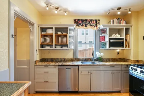 a kitchen with granite countertop a sink and cabinets