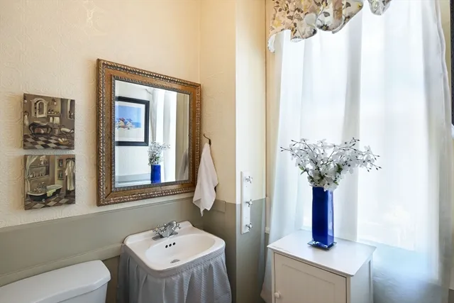 a bathroom with a sink a toilet and a mirror