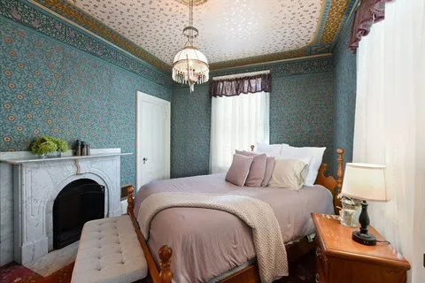 a bedroom with bed and a fireplace