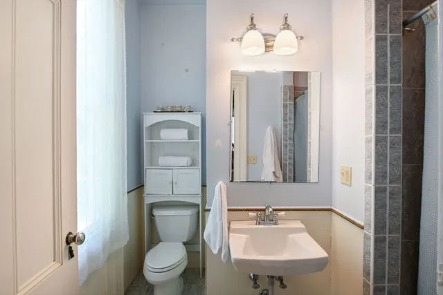 a bathroom with a toilet sink and mirror